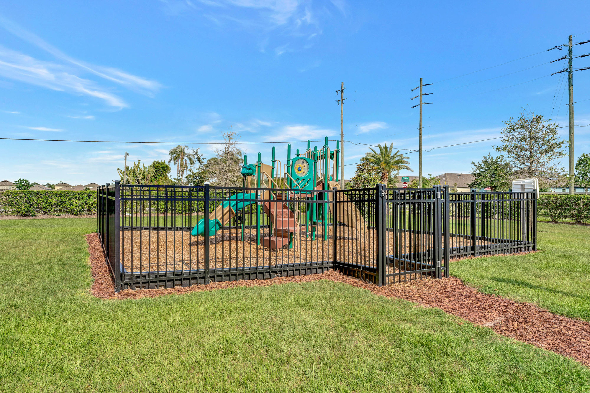 park with jungle gym and black metal fence surrounding it